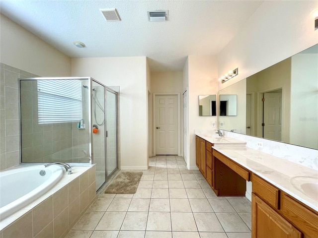 bathroom with separate shower and tub, tile patterned floors, vanity, and a textured ceiling