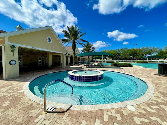 view of swimming pool featuring a patio area and a hot tub