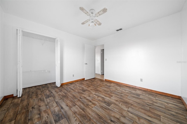 unfurnished bedroom with dark hardwood / wood-style flooring, ceiling fan, and a closet