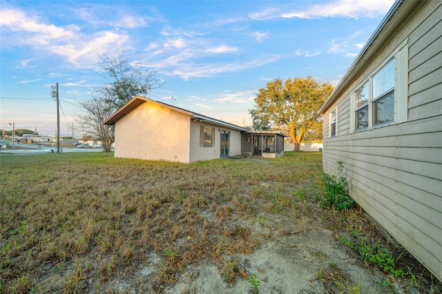 view of side of home featuring a sunroom and a water view