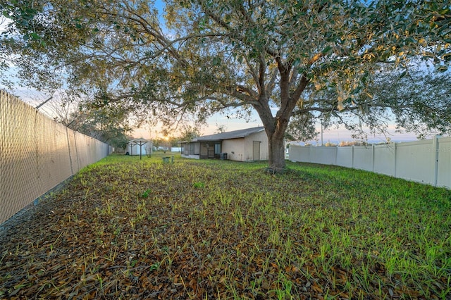 yard at dusk featuring a storage shed