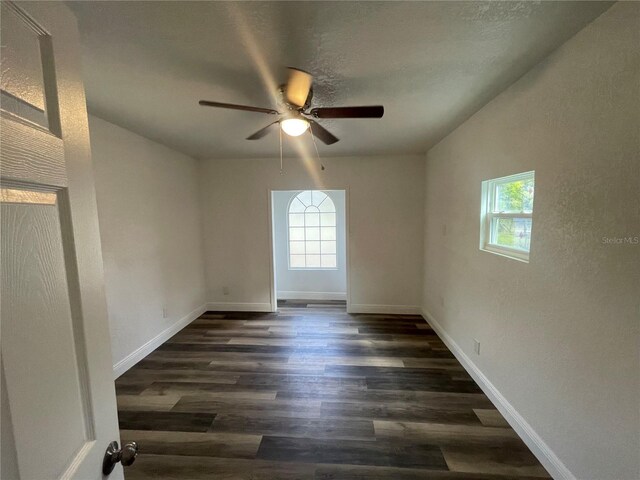 383 S Rooks Ave, Inverness, FL 34453 - empty room with dark wood-style floors, a ceiling fan, baseboards, and a healthy amount of sunlight