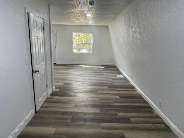 383 S Rooks Ave, Inverness, FL 34453 - unfurnished room with wood finished floors, visible vents, baseboards, a textured ceiling, and a textured wall
