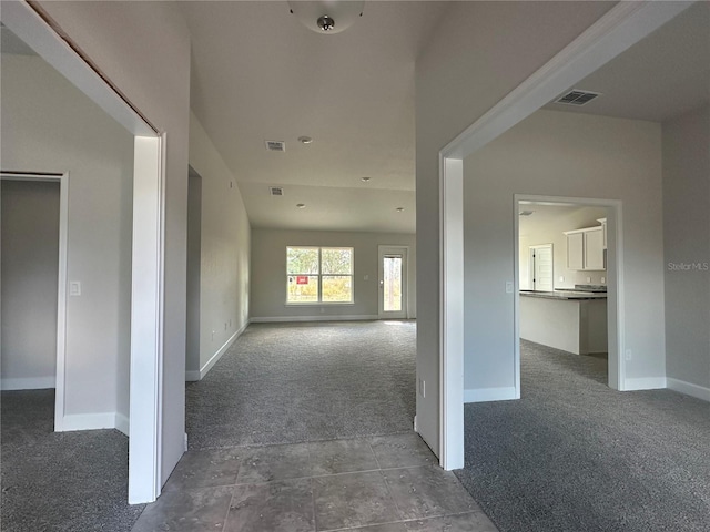 hallway featuring dark colored carpet