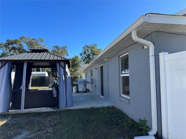 view of home's exterior with a gazebo and a patio