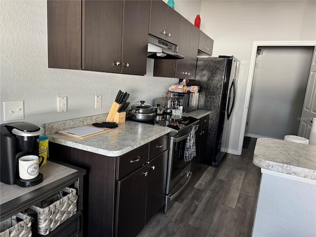 kitchen featuring dark hardwood / wood-style flooring, black fridge, dark brown cabinetry, and stainless steel electric range