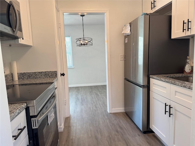 kitchen featuring white cabinets, pendant lighting, stainless steel appliances, and stone counters