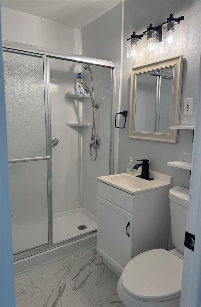 full bathroom featuring toilet, marble finish floor, a shower stall, and vanity