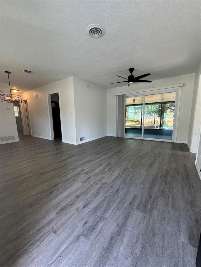 unfurnished living room featuring a textured ceiling, ceiling fan, and dark hardwood / wood-style floors