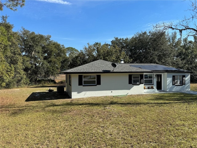 view of front of house featuring solar panels and a front lawn