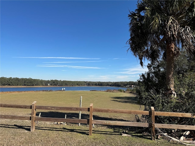 view of yard featuring a water view and fence