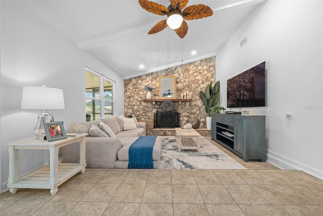 living room featuring ceiling fan, a stone fireplace, and vaulted ceiling with beams