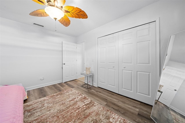 unfurnished bedroom featuring wood-type flooring, ceiling fan, and a closet