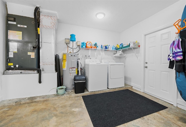 washroom with washer and dryer and water heater