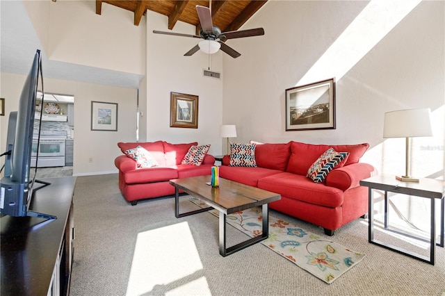 carpeted living room featuring beamed ceiling, ceiling fan, wooden ceiling, and high vaulted ceiling