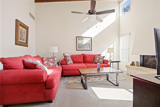 living room with carpet, ceiling fan, a multi sided fireplace, and a towering ceiling