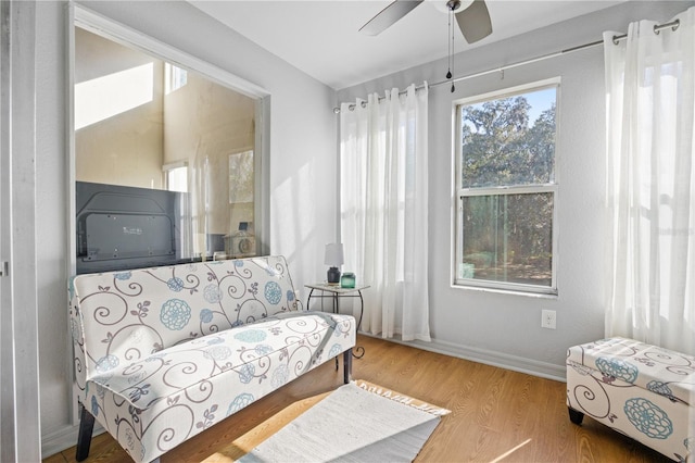 sitting room featuring ceiling fan, a healthy amount of sunlight, and wood-type flooring