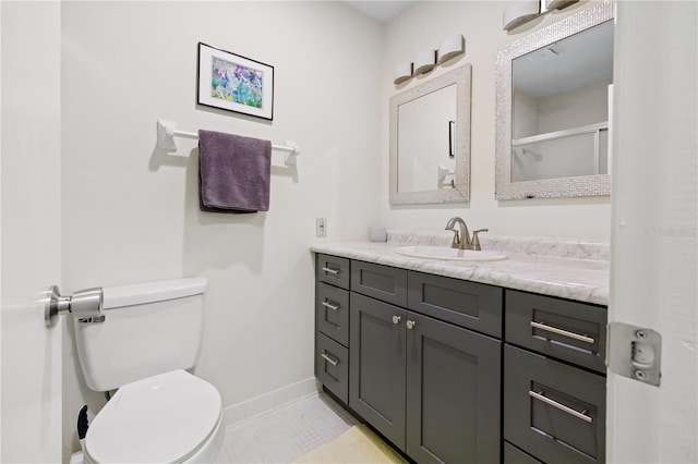 bathroom featuring tile patterned flooring, vanity, and toilet