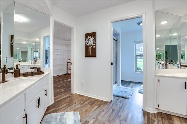 bathroom with hardwood / wood-style flooring, vanity, and a shower with door