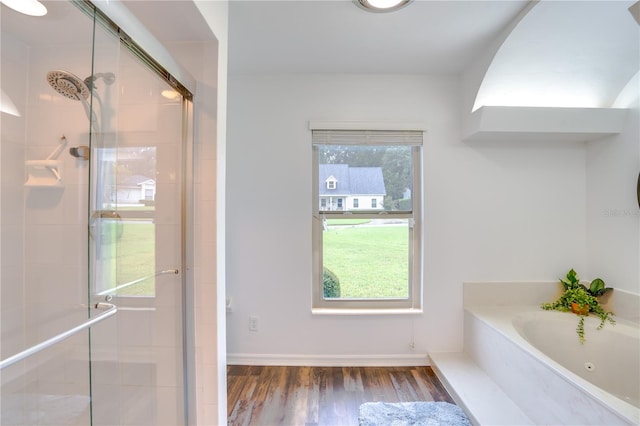 bathroom featuring wood-type flooring and shower with separate bathtub