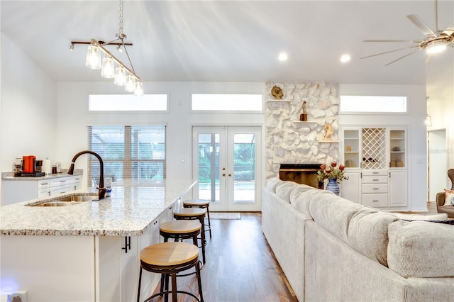 kitchen with french doors, sink, built in features, a fireplace, and hanging light fixtures