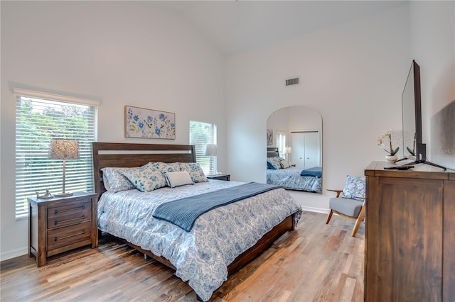 bedroom featuring hardwood / wood-style flooring and high vaulted ceiling