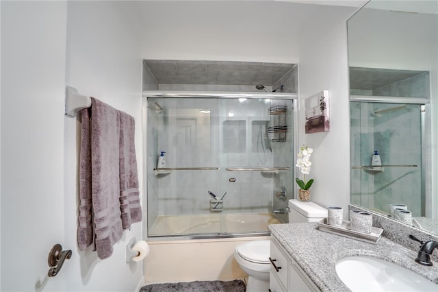 full bathroom with vanity, enclosed tub / shower combo, and toilet