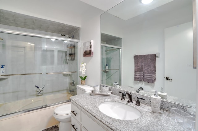 full bathroom with shower / bath combination with glass door, vanity, and toilet