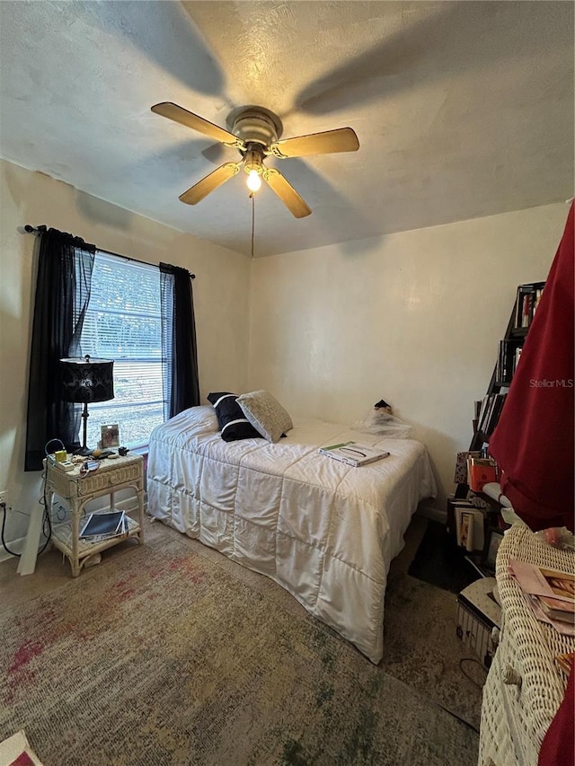 bedroom with carpet, ceiling fan, and a textured ceiling