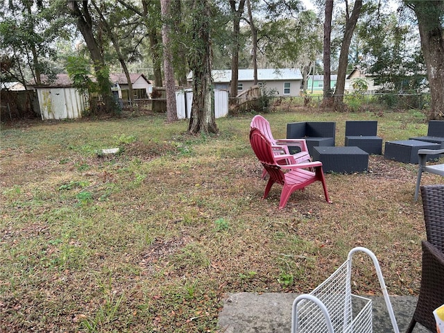 view of yard featuring an outbuilding, a fenced backyard, a storage shed, and an outdoor hangout area