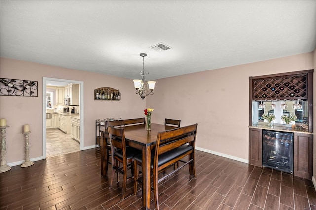 dining room featuring a notable chandelier, indoor bar, and beverage cooler