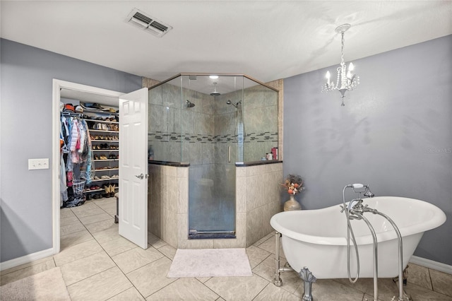 bathroom with a notable chandelier, tile patterned floors, and shower with separate bathtub