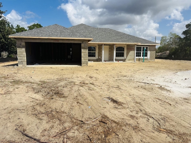 view of front of house with an attached garage and a shingled roof