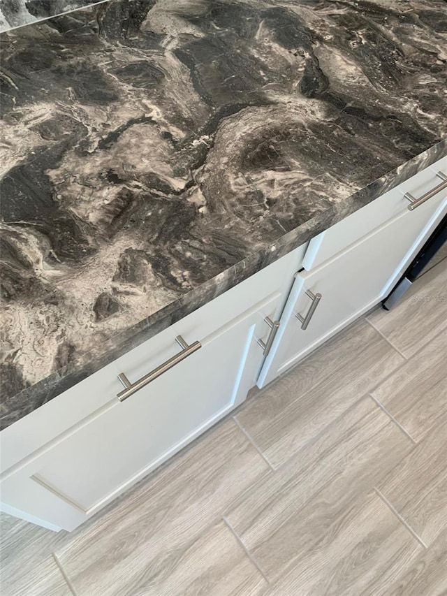 320 W Rexford Dr, Beverly Hills, FL 34465 - details featuring dark countertops, wood finish floors, and white cabinetry