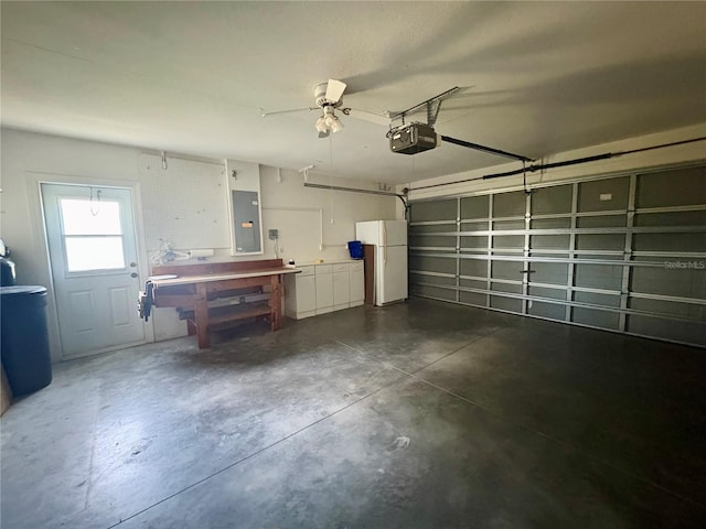 garage with white refrigerator, a garage door opener, electric panel, and ceiling fan