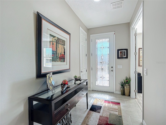 entryway with a textured ceiling and a wealth of natural light