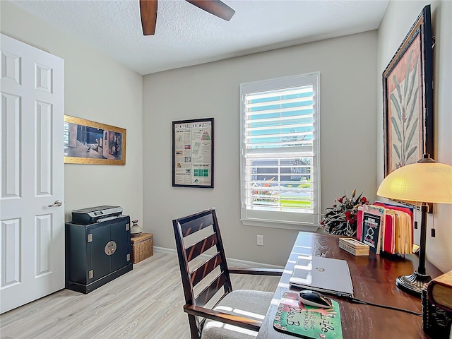 home office with a textured ceiling, ceiling fan, and light hardwood / wood-style floors