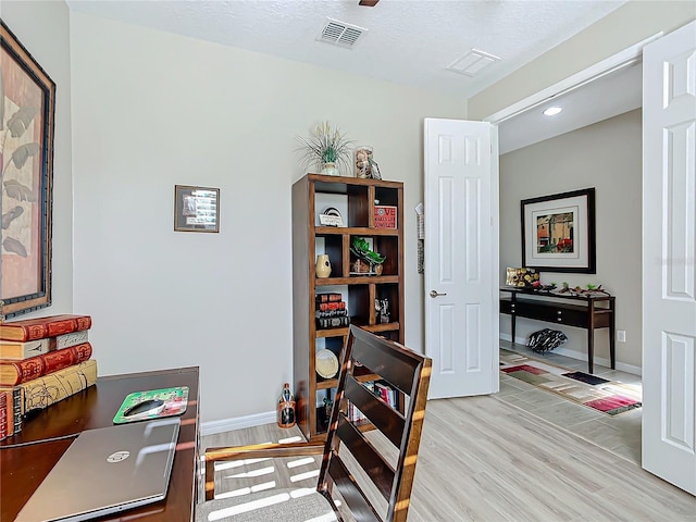 office space with a textured ceiling and light hardwood / wood-style floors