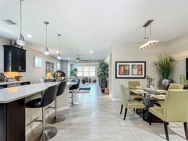 kitchen with a kitchen island, ceiling fan, pendant lighting, and a kitchen bar