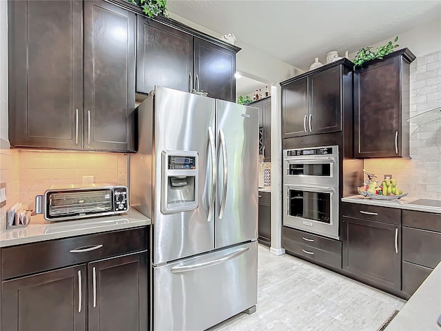 kitchen with appliances with stainless steel finishes, dark brown cabinets, and decorative backsplash