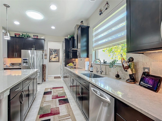 kitchen featuring stainless steel appliances, sink, pendant lighting, and tasteful backsplash