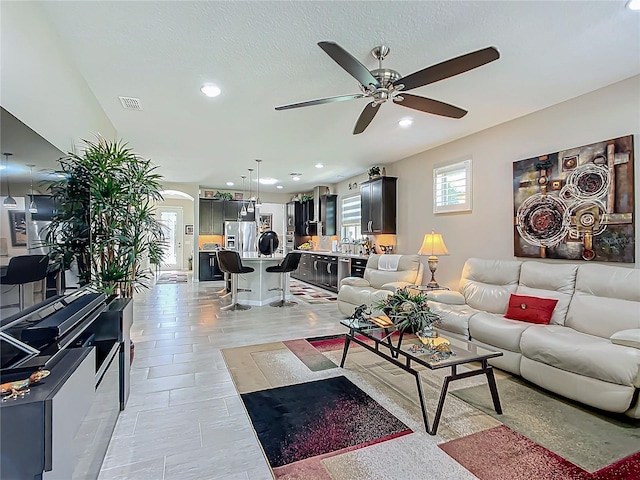 living room featuring light tile patterned flooring and ceiling fan