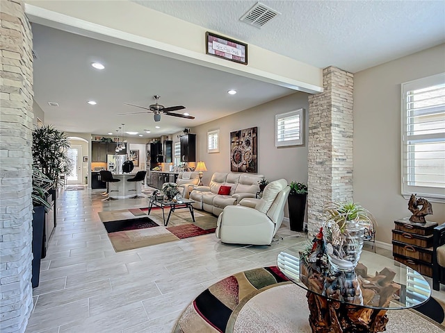 living room featuring a textured ceiling and ceiling fan