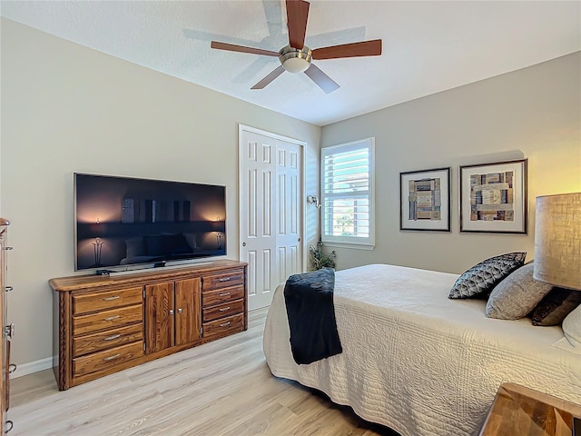 bedroom with a closet, ceiling fan, and light hardwood / wood-style floors