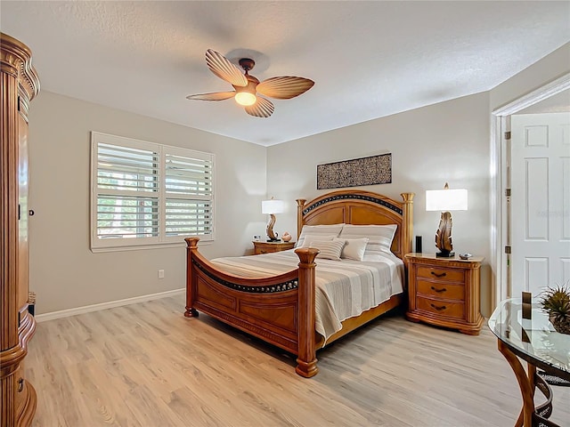 bedroom featuring light wood-type flooring, ceiling fan, and a textured ceiling