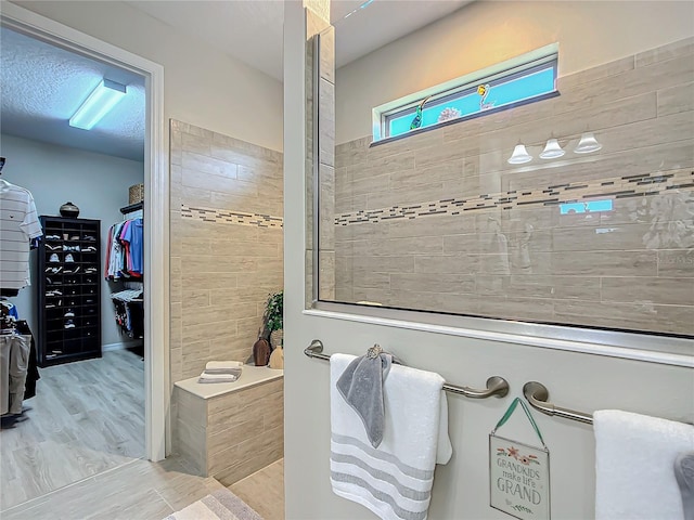 bathroom with a tile shower and hardwood / wood-style flooring