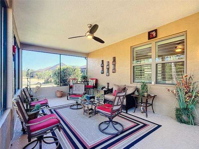 sunroom with ceiling fan and a mountain view