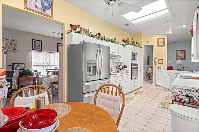 kitchen with stainless steel appliances, ceiling fan, sink, light tile patterned floors, and white cabinets