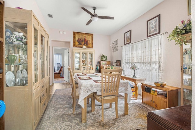 dining area with hardwood / wood-style floors and ceiling fan