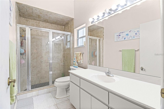 bathroom featuring toilet, vanity, tile patterned floors, and a shower with door